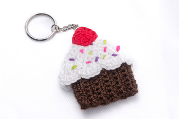 Obraz na płótnie Canvas Crocheted keychain in the shape of a vanilla and raspberry cupcake