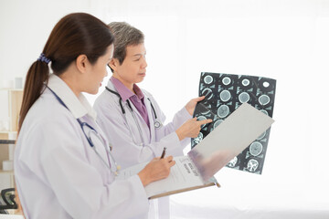 two Asian doctor looking patient film, head injury treatment, treatment consultation, brain scan