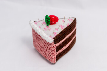 Obraz na płótnie Canvas Chocolate and raspberry cake pincushion with a strawberry on top
