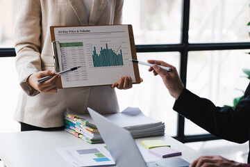 Business people working with financial documents analyzing business financial data together as a team.