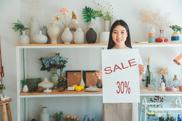 Smiling online small business owner holding a sign saying 