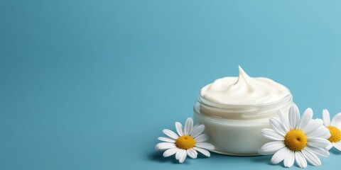 Obraz na płótnie Canvas Cosmetic cream with camomile flowers on blue background mockup.