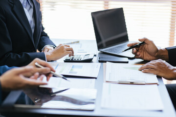 Close up view of business people discussing the charts and graphs showing the results of their successful teamwork.