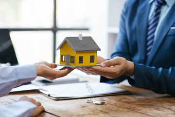 Close up Business people or Real Estate agent explain signing agreement for sale house to client. Property, Insurance, Broker concept.