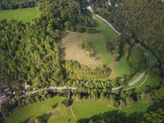Road through the green forest, Aerial view of the road and medieval city