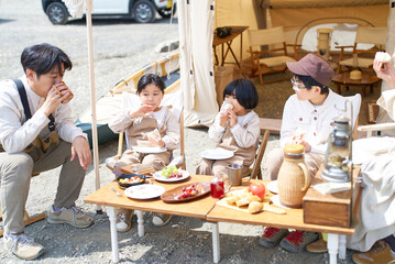 Fototapeta premium キャンプ場で食事を楽しむ家族