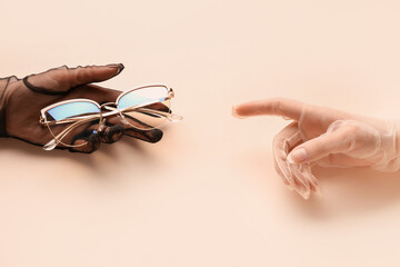 Women in laced gloves with eyeglasses on beige background
