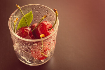 Cherries in a glass cup with drops of water