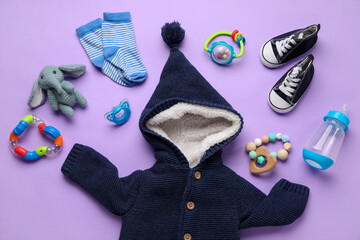 Composition with baby clothes, toys and accessories on lilac background