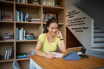 Female college student studying and working online with laptop and tablet at home