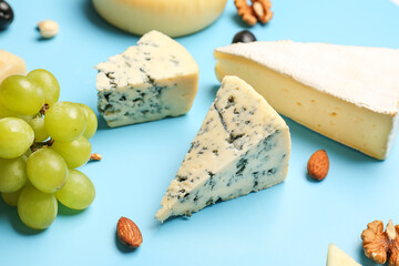 Pieces of tasty cheese on blue background