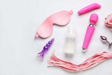 Bottle of lubricant and sex toys on grey background