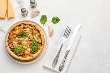 Mushroom pie with spinach leaves and cutlery on white background