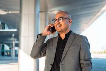 Senior manager business man in suit with cell phone at the buildings downtown. Confident man using smartphone looking towards their goals for success. Executive business man