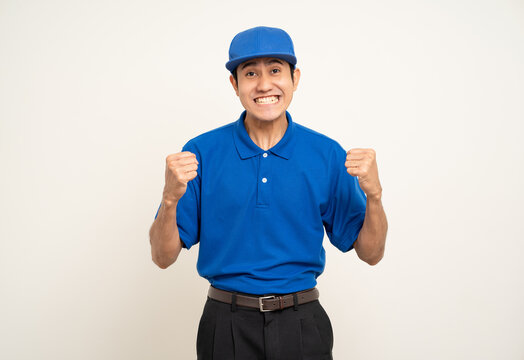 Happy delivery asian man in blue uniform standing on isolated white background. Smiling male service worker. Delivery courier and shipping service.