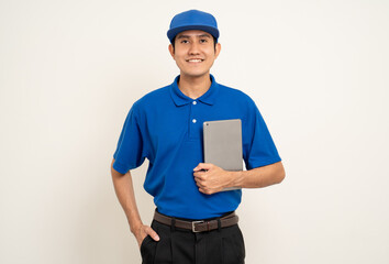 Asian man in blue uniform standing holding digital tablet computer on isolated white background....