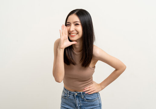 Happy beautiful asian woman with copy space. Excited pretty girl shout out loud wow with hands on mouth announcement standing pose on isolated white background.