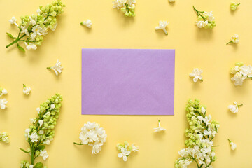 Blank card and beautiful lilac flowers on pale yellow background