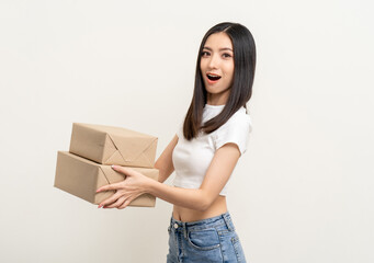 Young excited beautiful asian woman with many parcel cardboard standing on isolated white background. Cheerful female holding lot of parcel box receive from the delivery service