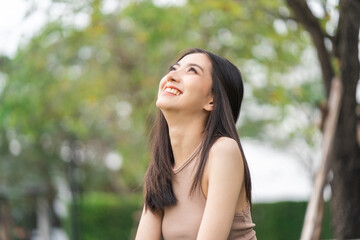 Happy feeling of Beautiful Young Woman smiling outdoor in sunlight. Pretty attractive face of female and beautiful smile. She is positive thinking and successful.