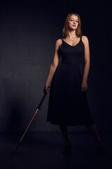 Fototapeta premium Stylish woman in black dress with katana