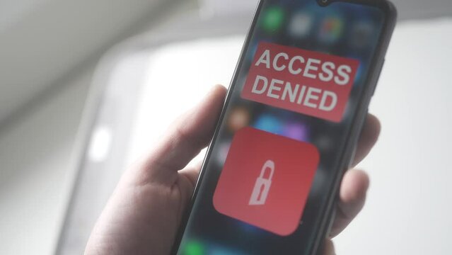 Holding a Smartphone with ACCESS DENIED Warning Message