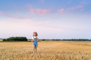 a little blonde curly girl running in a wheat field, the concept of human freedom