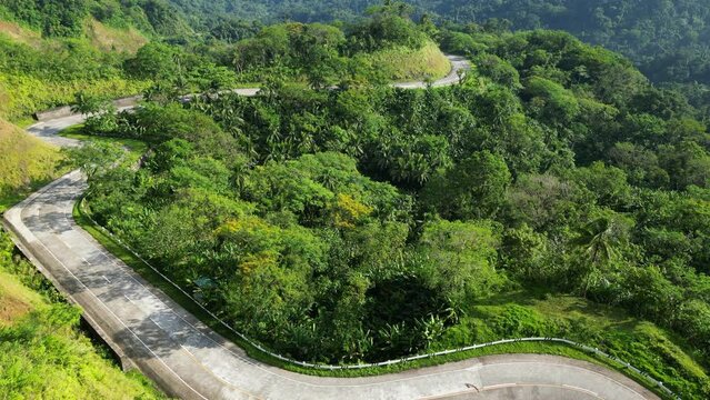 Scenic Landscape View of lush, tropical rainforest with winding roads along the mountainside. Catanduanes, Philippines. Aerial drone shot.