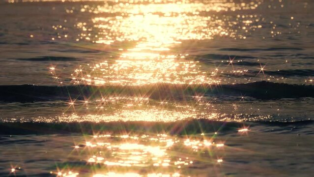 【夏】海の波が夕日をきらきらと反射しながら流れる風景　スローモーション