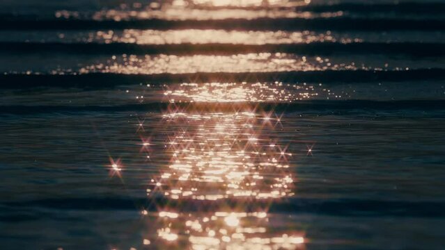 【夏】海の波が夕日をきらきらと反射しながら流れる風景　スローモーション