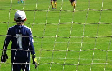 Soccer goal, with the goalkeeper in the foreground. Selective focus