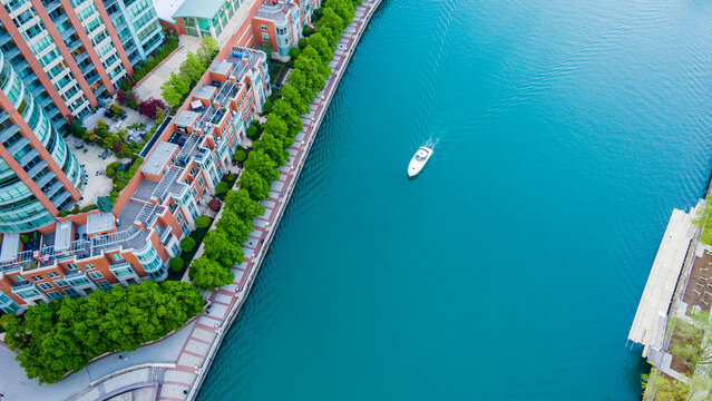 aerial drone view of the Chicago river with a boat sailing along the stream .  the water front is a great tourist destination for sight seeing and travel.  the blue water is beautiful and serene 