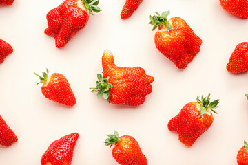 Fototapeta na wymiar Fresh strawberries, different in shape and size, flat lay, light beige background, top view