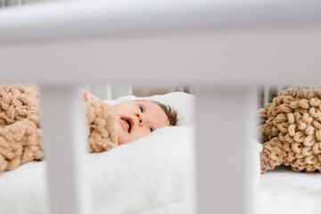 Newborn infant lay in wooden home crib