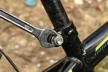 Torque the nut on a bicycle with an open end wrench.