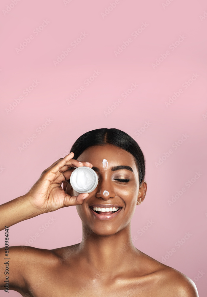 Wall mural Smile, skincare and woman with cream container in studio isolated on pink background mockup space. Eyes closed, creme cosmetics and Indian female model with lotion, moisturizer product or dermatology