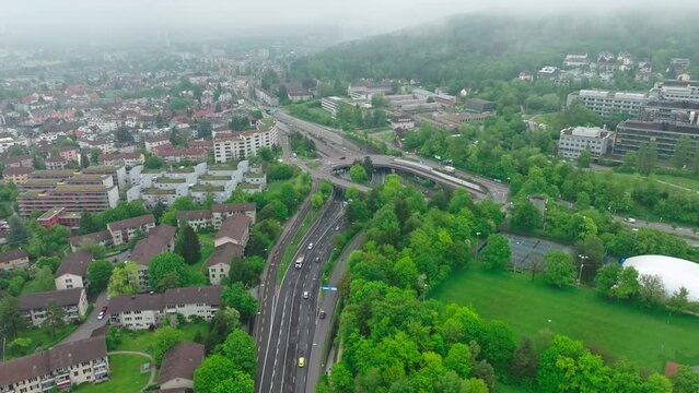 Aerial view of City of Z&uuml;rich with multiple lane highway and public park on a cloudy spring morning. Movie shot May 9th, 2023, Zurich, Switzerland.