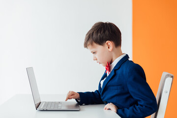 education IT knowledge child sitting at a laptop at school