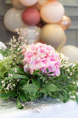 Table decoration with fresh, pink flowers. The focus is on the bouquet, the background is blurred. Holiday, postcard, event
