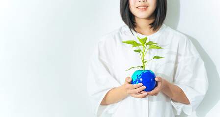 地球の描かれた植木鉢を持つ女の子　環境保護イメージ