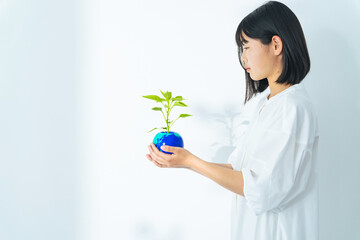 地球の描かれた植木鉢を持つ女の子　環境保護イメージ