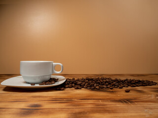 Obraz premium Cup of coffee and roasted coffee beans on a wooden background.