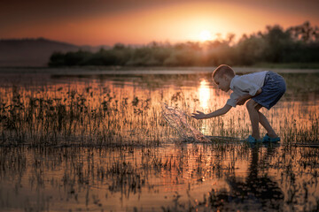 boy is playing with the water on the lake