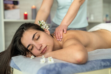 Obraz na płótnie Canvas Female client lying on table having rejuvenation massage on back in spa salon