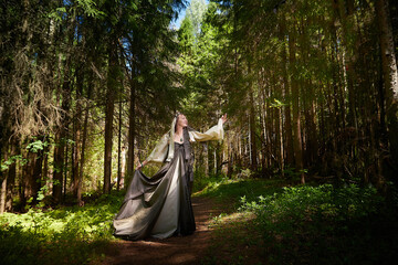 Naklejka premium Beautiful seductive dryad. Pagan spirit of the forest. Portrait of beautiful dryad. Fairy who loves nature in beautiful green summer forest. Concept of environmental friendliness and caring for nature