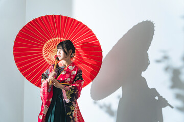 Portrait of Asian girl wearing kimono. Japanese traditional dress. Memorial ceremony. Photo studio.