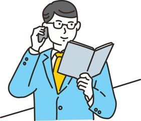 手帳を見ながら電話をするビジネスマン