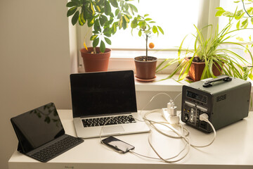 Portable power station charging tablet computer on table in living room