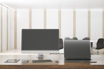 Modern designer office desktop with empty mock up computer screens, supplies and blurry interior background. 3D Rendering.
