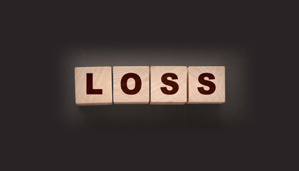 Wooden cubes with LOSS word on blacktable. Financial loss busines concept